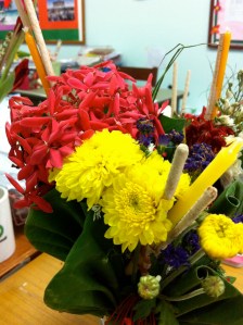 The flowers I brought back to my office.  All of the flowers are given in a cone made out of a leaf, and each kind of flower has a meaning.  The red flowers were the most common, and are said to symbolize intellectual ability.  The candles are for respect, along with 3 incense for luck.  